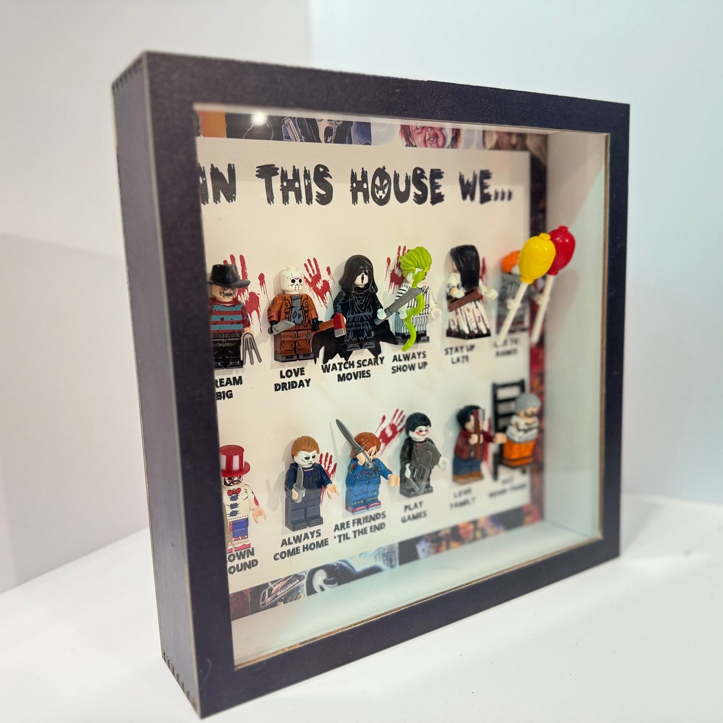 Decorative shadow box with LEGO figures and text on a white background