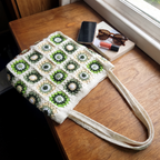 Ivory crochet green daisy granny square tote bag - size reference with phone, sunglasses and book