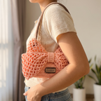 Pink crochet bow mesh shoulder bag - carried under the arm