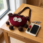 Red crochet cherry crossbody bag - size reference with phone and keys