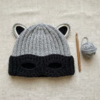 Raccoon Bandit Beanie flat lay with crochet hook